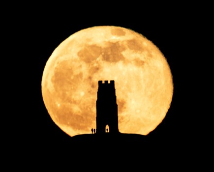 Silhouette of Glastonbury Tor, with the full moon rising behind
